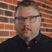 Man with short dark hair and glasses